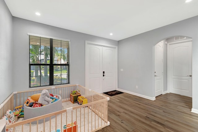 bedroom featuring a crib and hardwood / wood-style floors