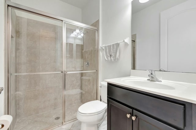 bathroom featuring vanity, toilet, and a shower with shower door