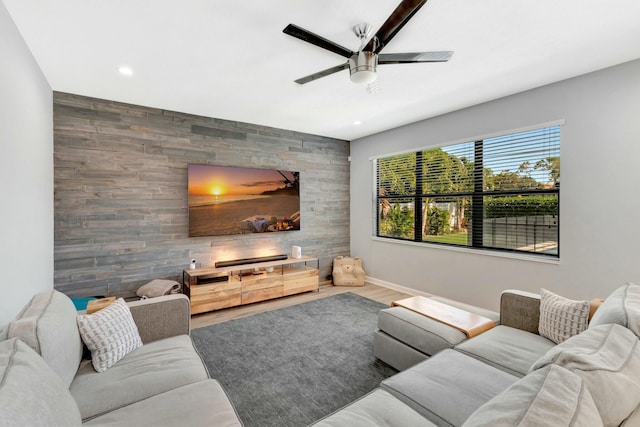 living room with ceiling fan, wooden walls, and hardwood / wood-style floors