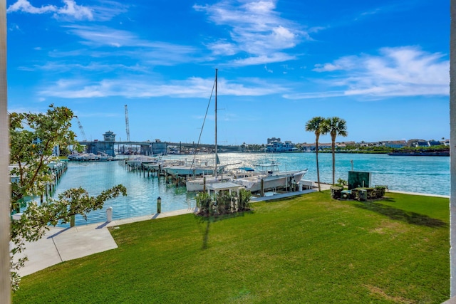 view of dock with a lawn and a water view