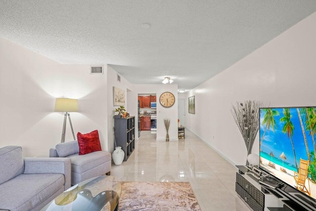 living room with a textured ceiling and light tile patterned floors