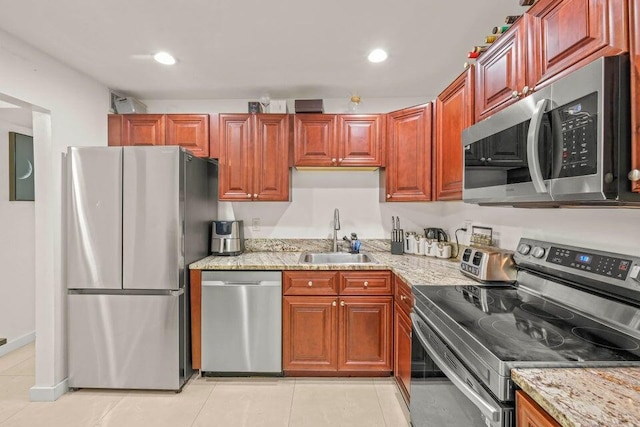 kitchen featuring light stone counters, stainless steel appliances, sink, and light tile patterned floors