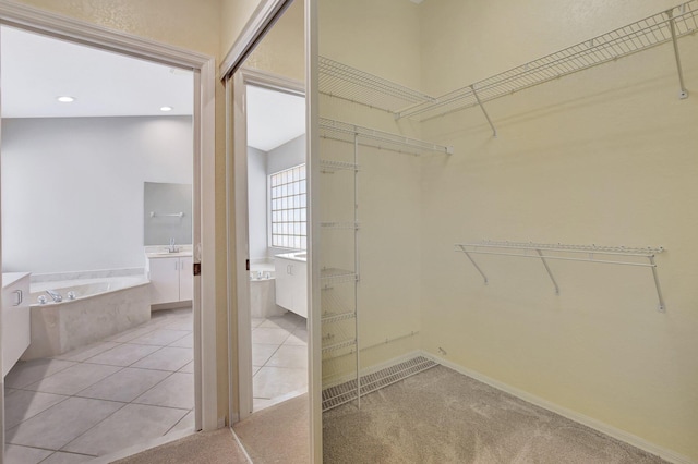 spacious closet featuring sink and light tile patterned floors