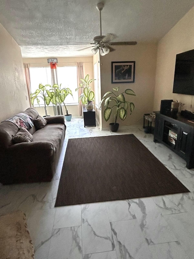 living room with ceiling fan and a textured ceiling