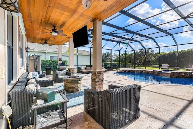 view of patio / terrace featuring a swimming pool with hot tub, glass enclosure, and an outdoor living space with a fire pit