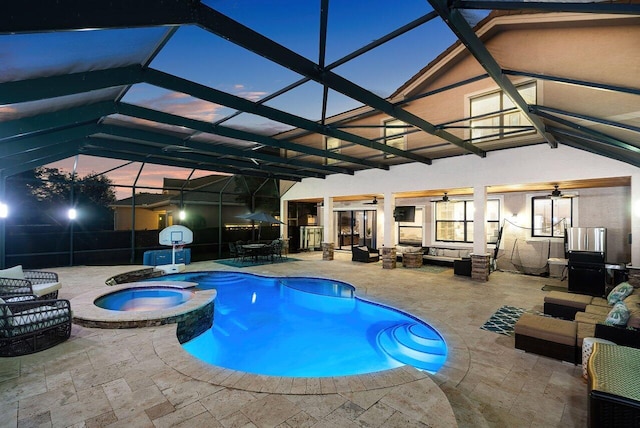 pool at dusk with an in ground hot tub