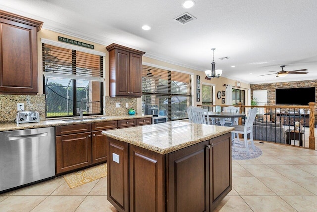 kitchen featuring sink, hanging light fixtures, a center island, stainless steel dishwasher, and crown molding