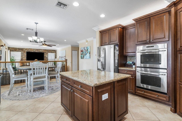 kitchen featuring stainless steel appliances, ornamental molding, a kitchen island, and light stone countertops