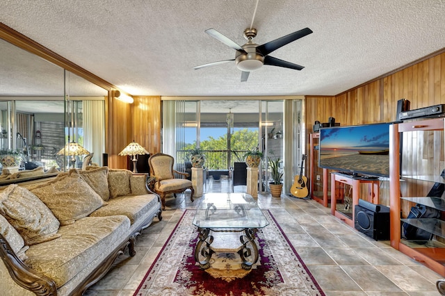 living room with ceiling fan, a wall of windows, a healthy amount of sunlight, and wooden walls