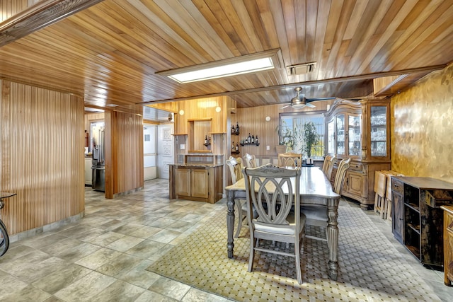 dining space featuring wood ceiling, wooden walls, and ceiling fan