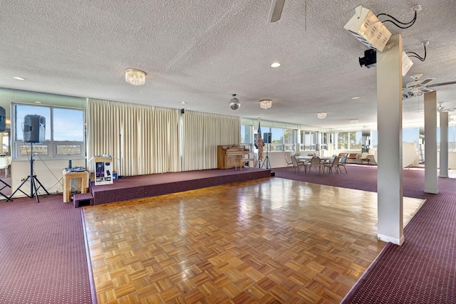 miscellaneous room with ceiling fan, parquet flooring, and a textured ceiling