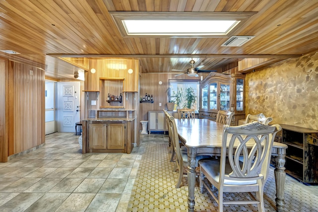 kitchen featuring wood ceiling, ceiling fan, light tile patterned floors, and wood walls