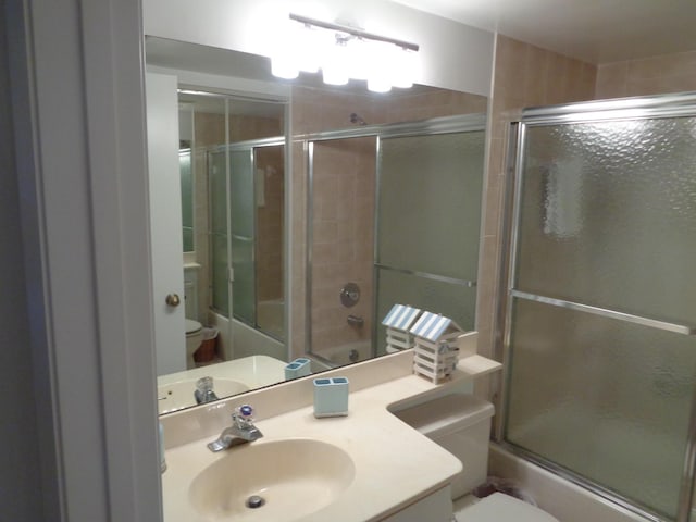 full bathroom with vanity, shower / bath combination with glass door, and toilet