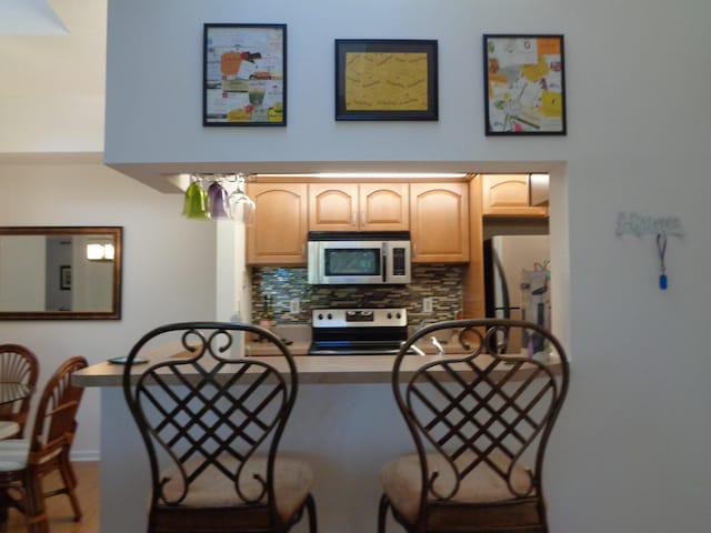 kitchen featuring light brown cabinetry, decorative backsplash, and appliances with stainless steel finishes