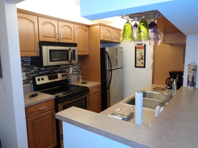 kitchen with tasteful backsplash, sink, stainless steel appliances, and kitchen peninsula