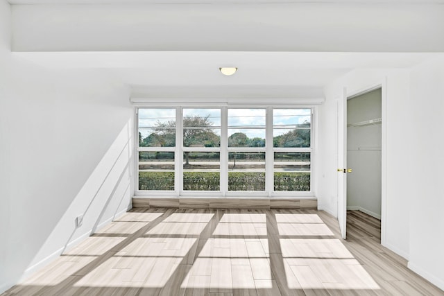 empty room with light wood-style flooring and baseboards