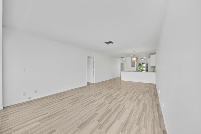 unfurnished living room with light wood finished floors and visible vents