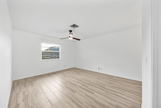 unfurnished room featuring a ceiling fan, visible vents, light wood finished floors, and baseboards