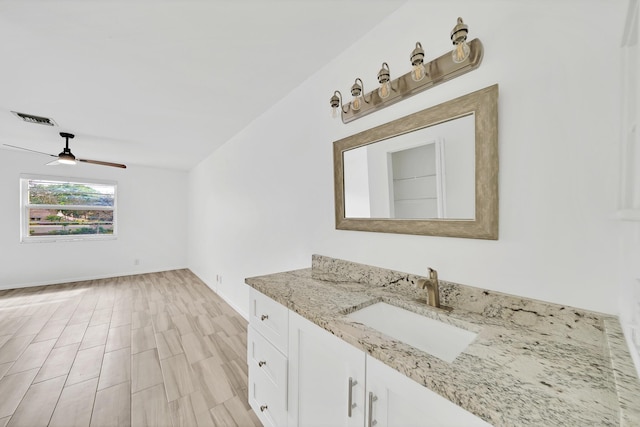 bathroom featuring visible vents, wood finished floors, a ceiling fan, and vanity