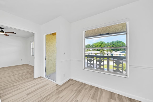 unfurnished room with ceiling fan, light wood-style flooring, and baseboards