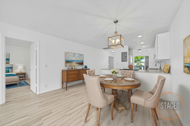 dining space with recessed lighting, light wood-style flooring, and an inviting chandelier