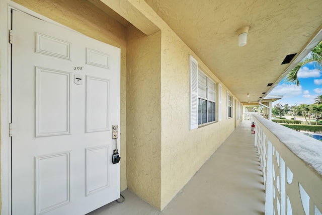 property entrance with a balcony and stucco siding