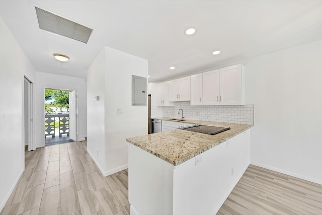 kitchen featuring light stone counters, a peninsula, visible vents, white cabinets, and decorative backsplash