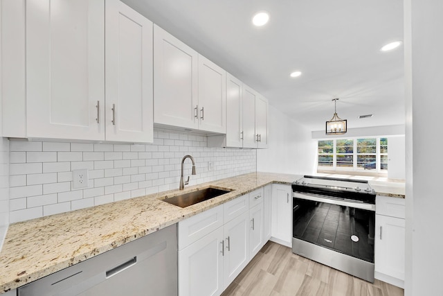 kitchen featuring appliances with stainless steel finishes, white cabinets, and a sink