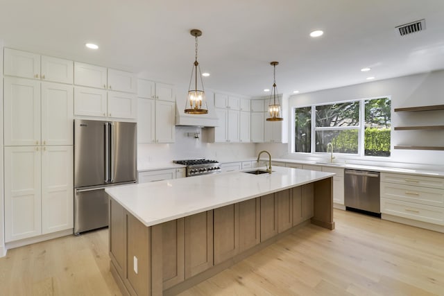 kitchen featuring white cabinetry, appliances with stainless steel finishes, sink, and a spacious island