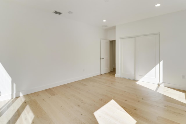 unfurnished bedroom featuring light hardwood / wood-style flooring and a closet