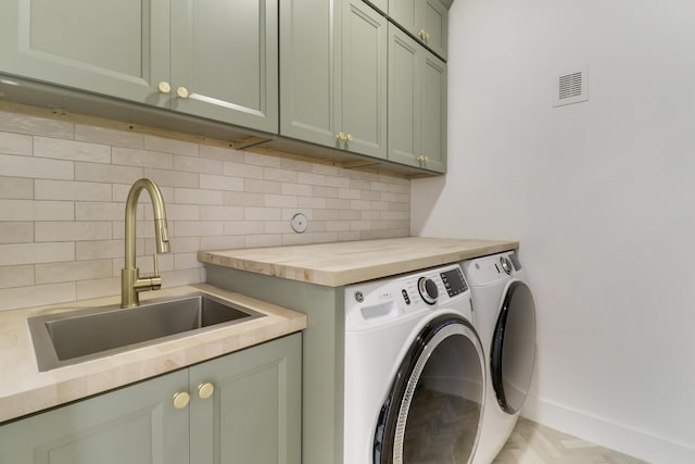 laundry area with cabinets, sink, and washing machine and clothes dryer