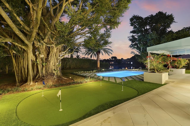 pool at dusk with a patio