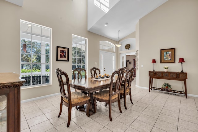 dining space with light tile patterned floors and high vaulted ceiling