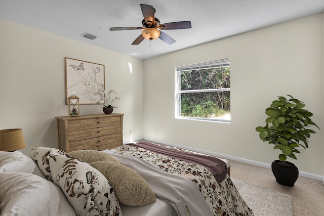 bedroom with carpet, visible vents, ceiling fan, a textured ceiling, and baseboards