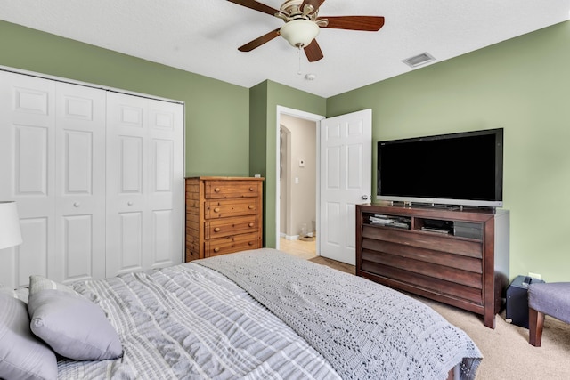 carpeted bedroom with ceiling fan and a closet