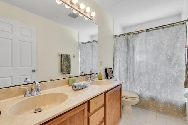 bathroom featuring vanity, toilet, and tile patterned flooring