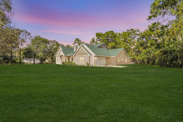 view of front of home featuring a garage and a yard