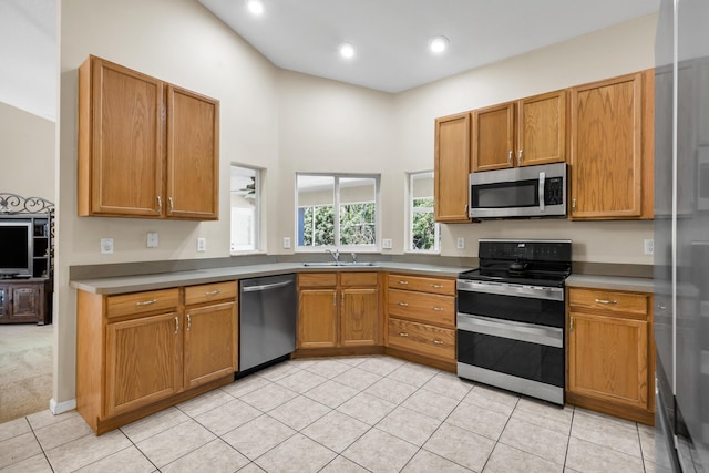 kitchen with stainless steel appliances, sink, and light tile patterned floors