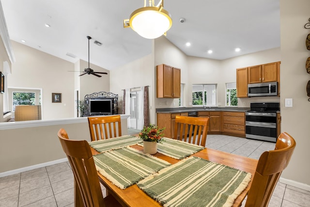 tiled dining area featuring ceiling fan, high vaulted ceiling, and sink