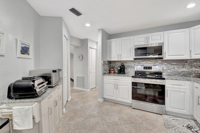 kitchen with light stone counters, decorative backsplash, white cabinets, and appliances with stainless steel finishes