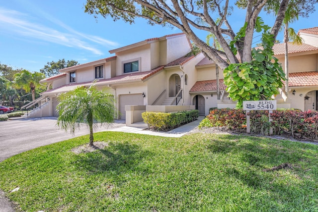 mediterranean / spanish house with a garage and a front yard