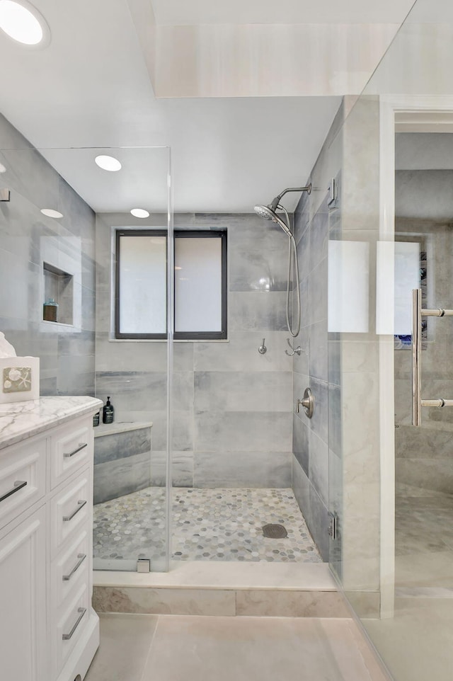 bathroom with tile patterned flooring, vanity, and a shower with shower door