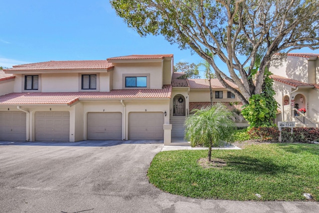 mediterranean / spanish house with a garage and a front yard