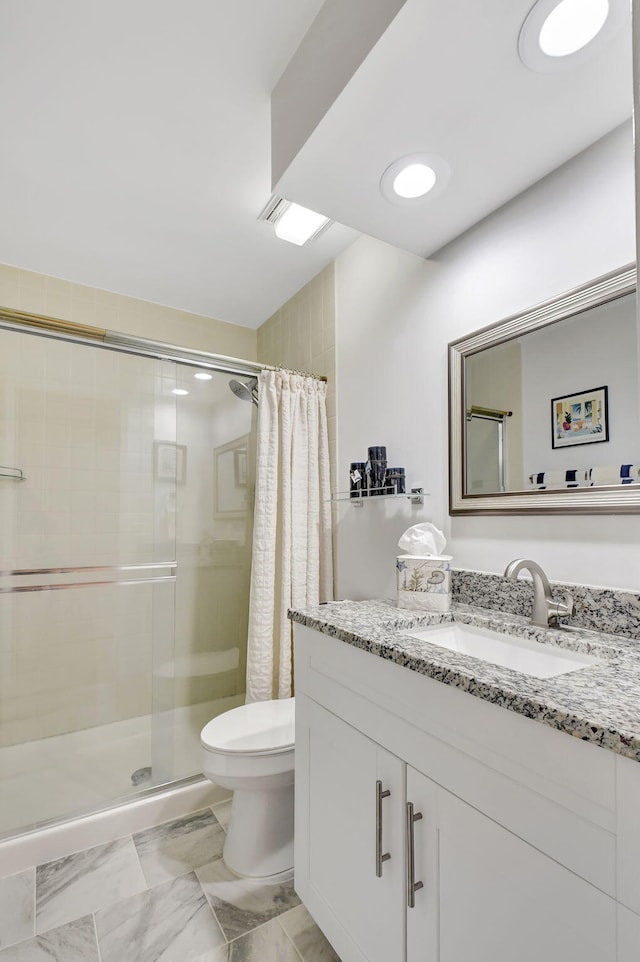 bathroom featuring walk in shower, vanity, and toilet