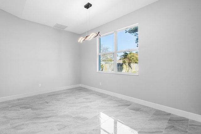 unfurnished room featuring a notable chandelier