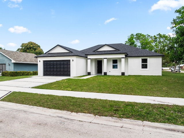 view of front of property with a garage and a front lawn