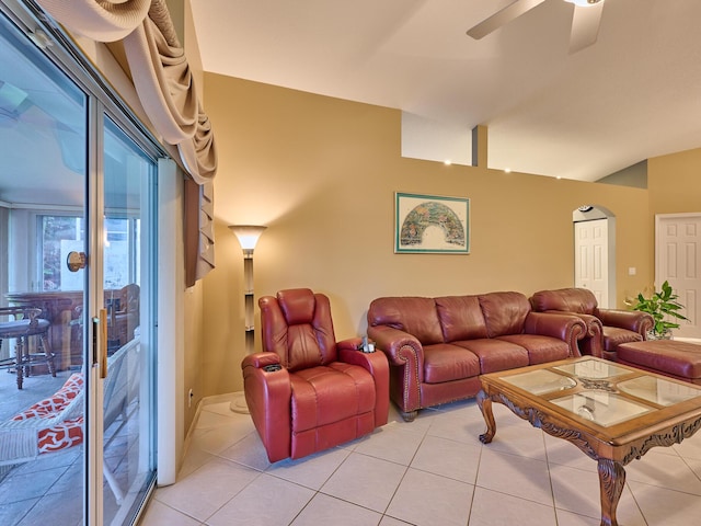 tiled living room featuring ceiling fan and vaulted ceiling