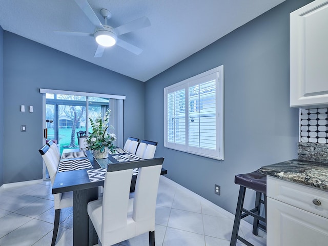 dining room with plenty of natural light, vaulted ceiling, and light tile patterned floors