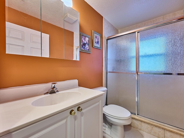 bathroom featuring vanity, toilet, a textured ceiling, and a shower with shower door