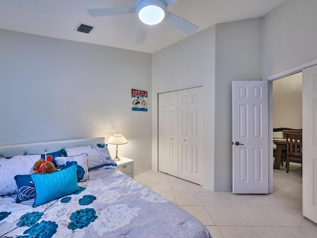 bedroom with ceiling fan, a closet, and light tile patterned floors